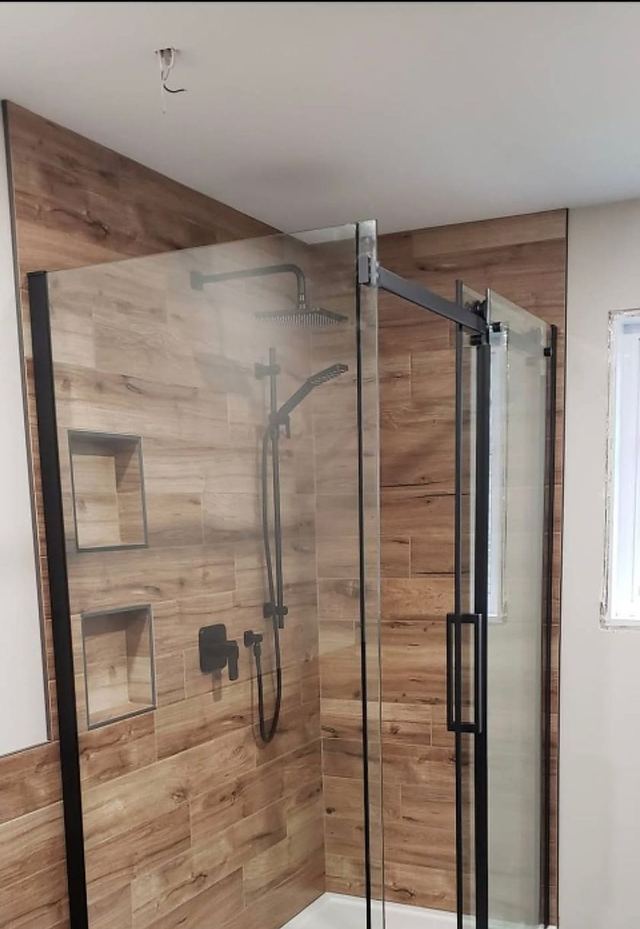 Douche à l’italienne carrelage effet bois avec paroi en verre et profilés noirs